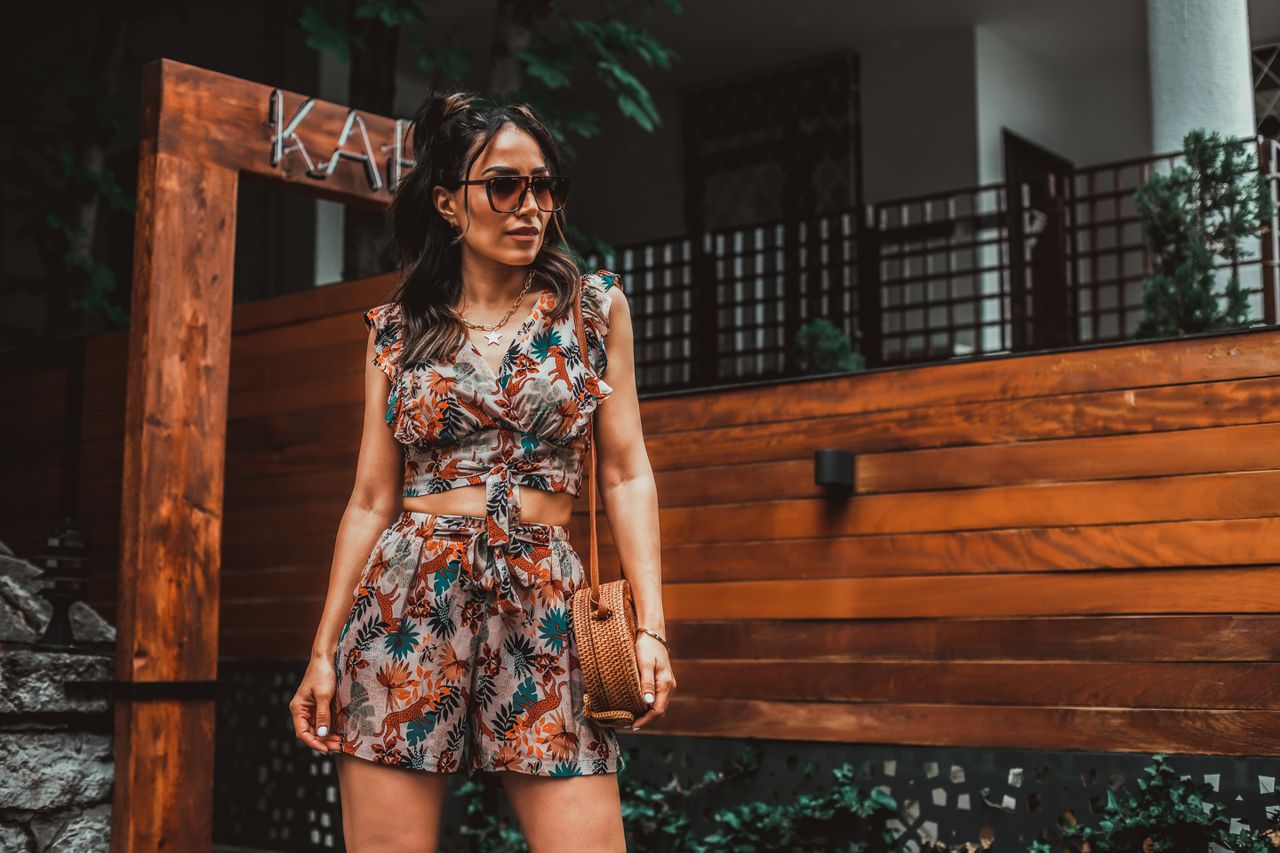 Fashion-forward woman in summer attire standing confidently outdoors, exuding style and elegance.
