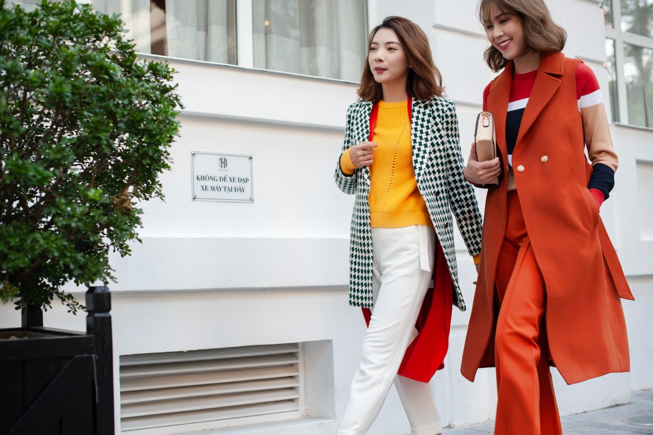 Two fashionable women walking, showcasing vibrant street fashion with confidence.